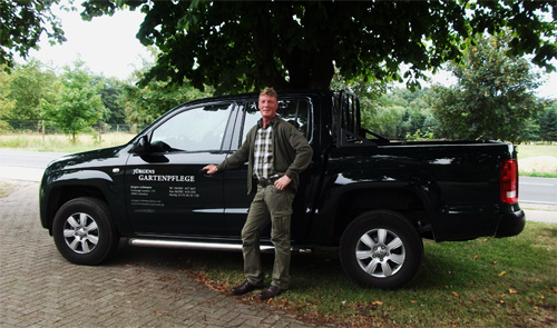 The picture shows Jürgen Lohmann in front of his Pick-Up truck (VW Amorak) for the transport of animals